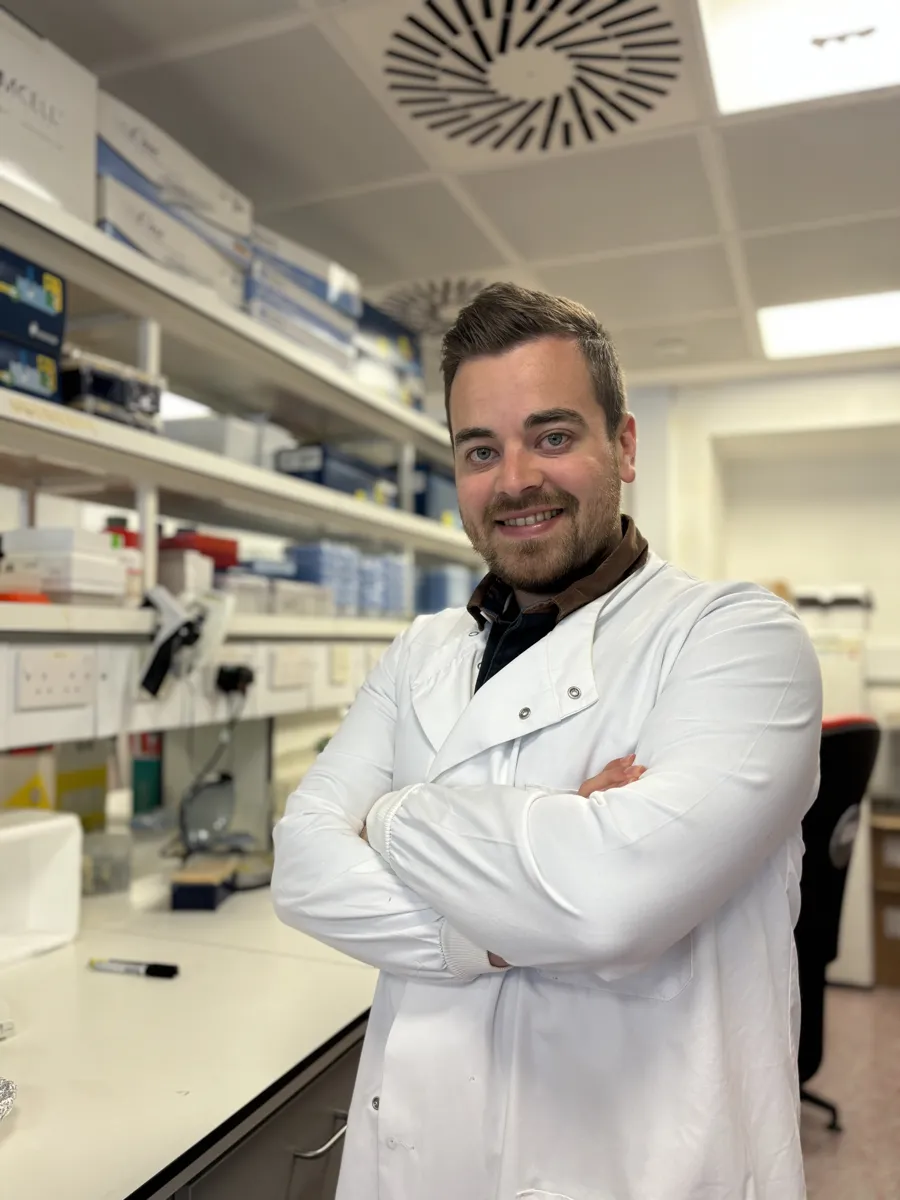 Dr George Robinson in the lab, wearing a lab coat